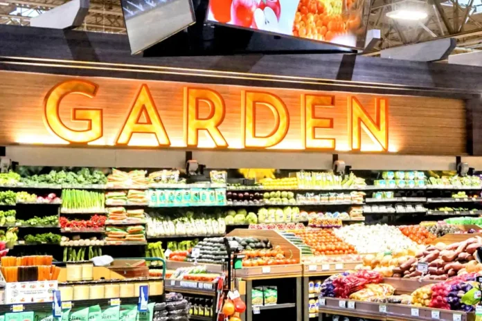 Albertsons in-store produce section with digital display screen above fresh vegetables